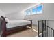 Cozy bedroom featuring a sloped ceiling, three windows, and access to a staircase at 112 Illinois Gulch Rd # 6, Breckenridge, CO 80424