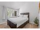 Relaxing bedroom with a dark wood bed frame, plant, plush carpet, and sunlit window at 112 Illinois Gulch Rd # 6, Breckenridge, CO 80424