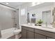 Bathroom features double sink vanity, shower over bath with light gray tiling and a large mirror at 25106 E 1St Ave, Aurora, CO 80018