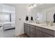 Well-lit bathroom boasts double sinks, stylish fixtures, and an open doorway to the main bedroom at 25106 E 1St Ave, Aurora, CO 80018