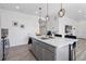 Kitchen island boasts white quartz countertops, gray cabinets, and sleek stainless faucet at 25106 E 1St Ave, Aurora, CO 80018