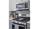 Gas range with stainless steel microwave and white cabinets in the modern kitchen at 25106 E 1St Ave, Aurora, CO 80018