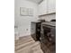 Laundry room with front load washer and dryer, white cabinets, and wood-look flooring at 25106 E 1St Ave, Aurora, CO 80018