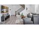 Bright living room features modern decor, stylish flooring, and a staircase, creating a welcoming atmosphere at 25106 E 1St Ave, Aurora, CO 80018