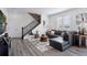 Open-concept living area boasts natural light, sleek gray couches, and trendy accents at 25106 E 1St Ave, Aurora, CO 80018