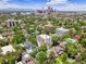 An aerial view showcases the building surrounded by lush greenery, a pool, and the city skyline at 1050 N Lafayette St # 408, Denver, CO 80218