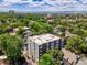 Aerial view of a brick apartment building surrounded by trees and featuring a cityscape in the background at 1050 N Lafayette St # 408, Denver, CO 80218