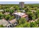 An aerial view showcases the building surrounded by lush greenery and city views in the background at 1050 N Lafayette St # 408, Denver, CO 80218