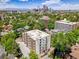 An aerial view of a building surrounded by lush trees, with a city skyline in the distance at 1050 N Lafayette St # 408, Denver, CO 80218