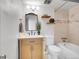Bathroom with single sink vanity, tub shower combo and decorative plants with convenient shelving at 1050 N Lafayette St # 408, Denver, CO 80218