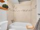 Bathroom featuring white tub with neutral tile walls, and wooden shelf with decor at 1050 N Lafayette St # 408, Denver, CO 80218