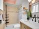 Bathroom featuring tiled shower with gold fixtures, a vanity with storage, and modern design at 1050 N Lafayette St # 408, Denver, CO 80218