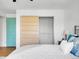 Bedroom with a modern closet and bright teal door, showing a warm and inviting interior space at 1050 N Lafayette St # 408, Denver, CO 80218