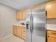 Kitchen featuring stainless steel refrigerator with light wood cabinets and neutral wallpaper at 1050 N Lafayette St # 408, Denver, CO 80218