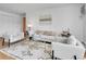 Bright living room featuring modern white furnishings, a glass coffee table, and a patterned rug on wood floors at 1050 N Lafayette St # 408, Denver, CO 80218