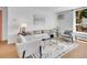 Bright living room featuring modern white furnishings, a glass coffee table, and a patterned rug on wood floors at 1050 N Lafayette St # 408, Denver, CO 80218