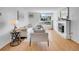 Bright living room with wood floors, white fireplace, and large window showcasing natural light and modern furnishings at 1050 N Lafayette St # 408, Denver, CO 80218