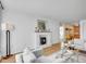 Bright living room with wood floors, white fireplace, and modern furnishings with open doorway to eat in kitchen at 1050 N Lafayette St # 408, Denver, CO 80218