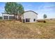Backyard with a two-story home, patio with sliding glass door, and large trees at 2845 Cherry Way, Parker, CO 80138