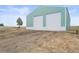 Detached two-car garage with white doors, green exterior, and gravel driveway at 2845 Cherry Way, Parker, CO 80138