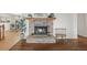 Cozy living room with a brick fireplace, hardwood floors, and access to the adjacent kitchen at 2845 Cherry Way, Parker, CO 80138