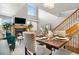 Open concept dining room featuring a fireplace, television, staircase, and large window for natural light at 5155 W 68Th Ave # 5, Westminster, CO 80030