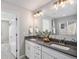 Bathroom featuring double vanity with gray counter and white cabinets, stylish fixtures, and walk-in closet at 1011 White Leaf Cir, Castle Rock, CO 80108