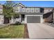 Charming two-story home with a well-manicured lawn, gray siding, and a two-car garage at 1011 White Leaf Cir, Castle Rock, CO 80108
