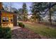 The manicured backyard has an outdoor patio area, with mature trees in the background at 1 Canon Pl, Greenwood Village, CO 80111