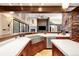 Kitchen with stone accents, white countertops, stainless appliances and dark wood cabinets at 1 Canon Pl, Greenwood Village, CO 80111
