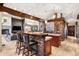 Open kitchen with a stone accent wall, a breakfast bar, and a view into the living room at 1 Canon Pl, Greenwood Village, CO 80111