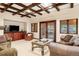 Living room with backyard access, coffered ceilings, and views of the outdoor landscape at 1 Canon Pl, Greenwood Village, CO 80111