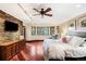 Spacious bedroom featuring wood floors, bay window, stone accent wall, and entertainment center at 1 Canon Pl, Greenwood Village, CO 80111