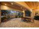 This sheltered outdoor patio has stone pillars, brickwork, and seating, with pretty trees in the background at 1 Canon Pl, Greenwood Village, CO 80111