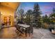 The stone patio has seating for outdoor dining and entertaining, with pretty trees in the background at 1 Canon Pl, Greenwood Village, CO 80111