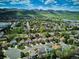 Breathtaking aerial view of a vibrant community nestled against a backdrop of rolling mountains and lush green landscapes at 7354 S Robb St, Littleton, CO 80127
