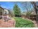 Lush backyard features a stamped patio, green grass and wooden fence for a peaceful retreat at 7354 S Robb St, Littleton, CO 80127