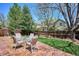 Beautiful backyard featuring a stone patio, seating, lush green grass, and a wooden fence at 7354 S Robb St, Littleton, CO 80127