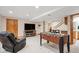 Finished basement featuring a tv, game table, bar, and comfortable chair at 7354 S Robb St, Littleton, CO 80127