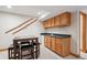 Basement bar area with table and chairs, bar sink, and storage cabinets at 7354 S Robb St, Littleton, CO 80127