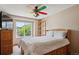 Comfortable bedroom with ceiling fan, large window providing natural light, and wooden furniture at 7354 S Robb St, Littleton, CO 80127