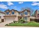 Charming two-story home with manicured lawn, mature landscaping, and neutral color palette at 7354 S Robb St, Littleton, CO 80127