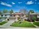 Well-maintained two-story home with a manicured lawn, mature landscaping, and a two-car garage at 7354 S Robb St, Littleton, CO 80127