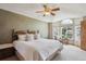 Relaxing main bedroom with large window, ceiling fan, and plush bed at 7354 S Robb St, Littleton, CO 80127