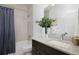 Well-lit bathroom featuring a shower-tub combo, dark wood vanity, and modern fixtures at 2857 S Pancratia St, Denver, CO 80236