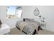 Cozy bedroom with a black and white patterned bed, a round wall mirror and large window at 2857 S Pancratia St, Denver, CO 80236