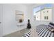 Bright bedroom with a modern desk, a guitar, and a window view of a house with an American flag at 2857 S Pancratia St, Denver, CO 80236