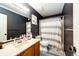 Stylish bathroom featuring a vanity with a large mirror and a shower with a patterned curtain at 1824 Asoka St, Strasburg, CO 80136