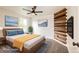 Modern bedroom with a unique wooden wall accent and ceiling fan at 1824 Asoka St, Strasburg, CO 80136