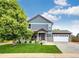 Charming two-story home with well-manicured lawn, attached garage, and covered front porch at 1824 Asoka St, Strasburg, CO 80136